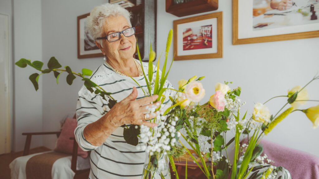 Senior woman arranging flowers at home
