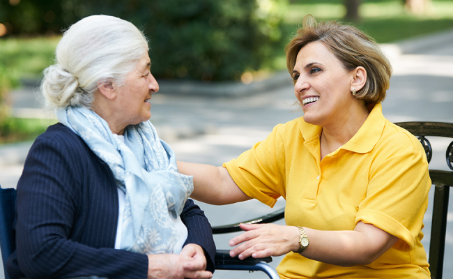 Senior woman and daughter talking to each other on the bench