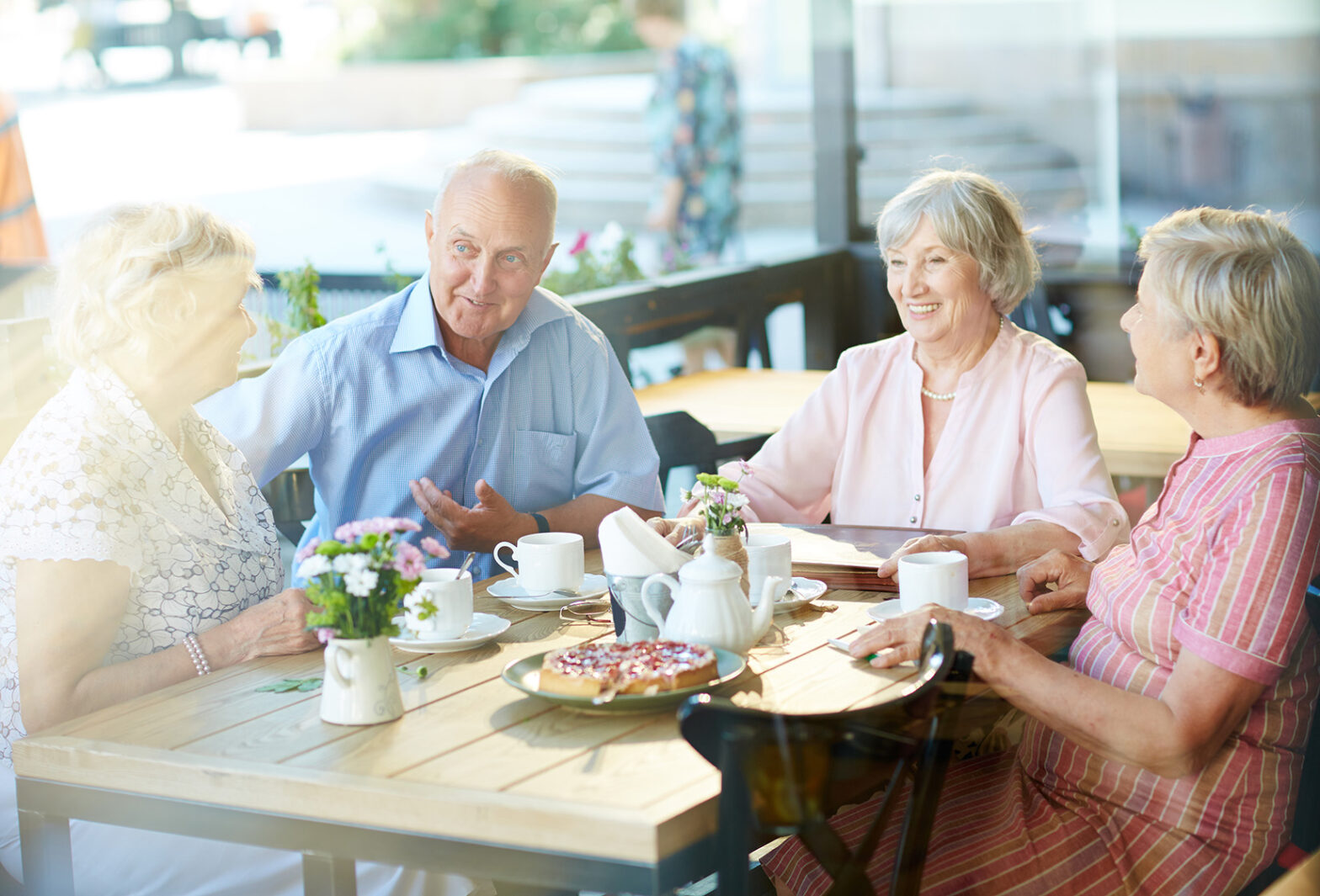 Seniors talking in cafe on sunny day