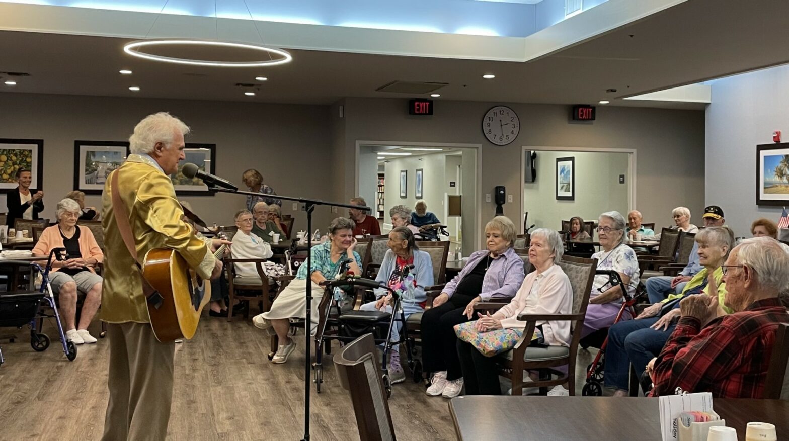 A gathering of seniors enjoying a performance from a Holiday resident