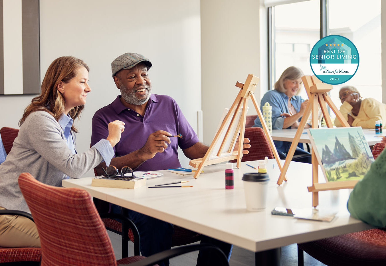 Two people painting together in an art room