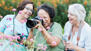 Three senior woman taking photos outside