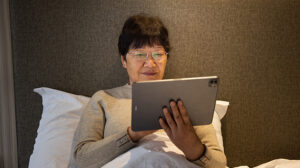 Senior woman sitting in bed and using iPad