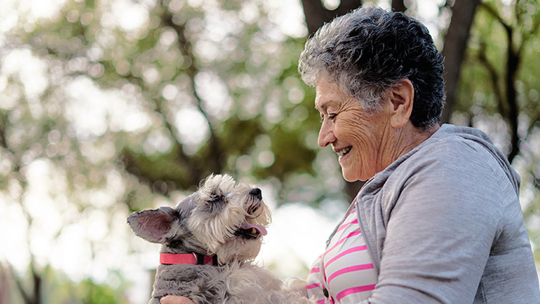 Senior woman enjoying time outside with her dog