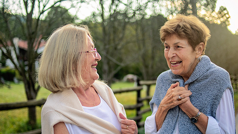 Two senior women talking outside