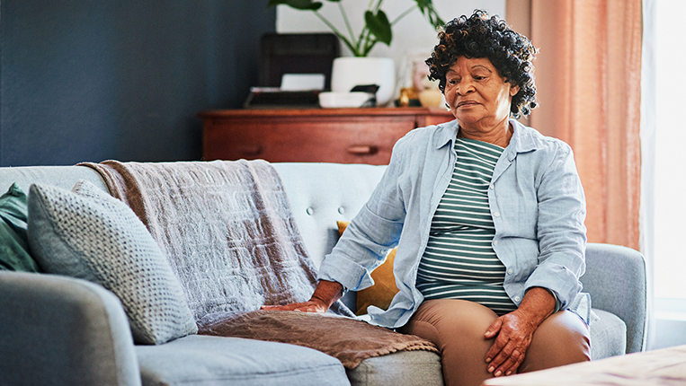 Shot of an elderly woman looking unhappy on the sofa at home