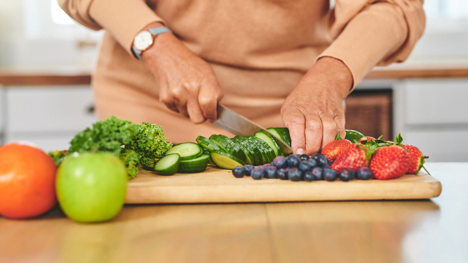 Senior chopping veggies on wood cutting board