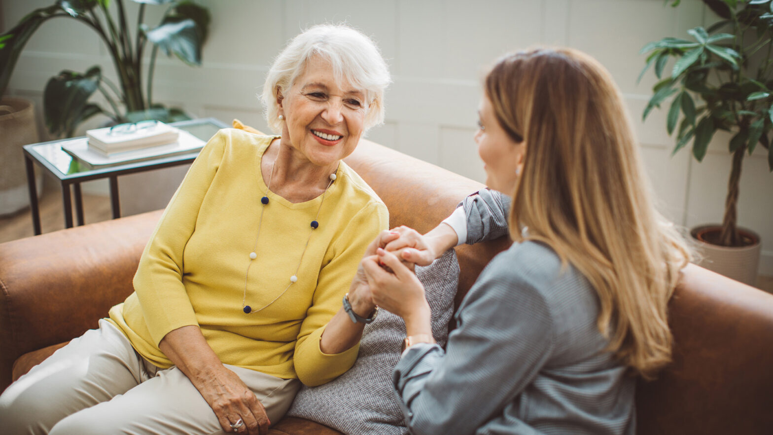 Senior woman talking with her daughter at home.