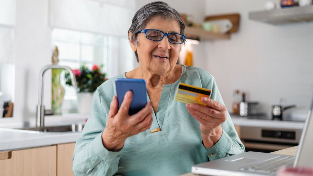 Senior woman using her credit card to make an online purchase