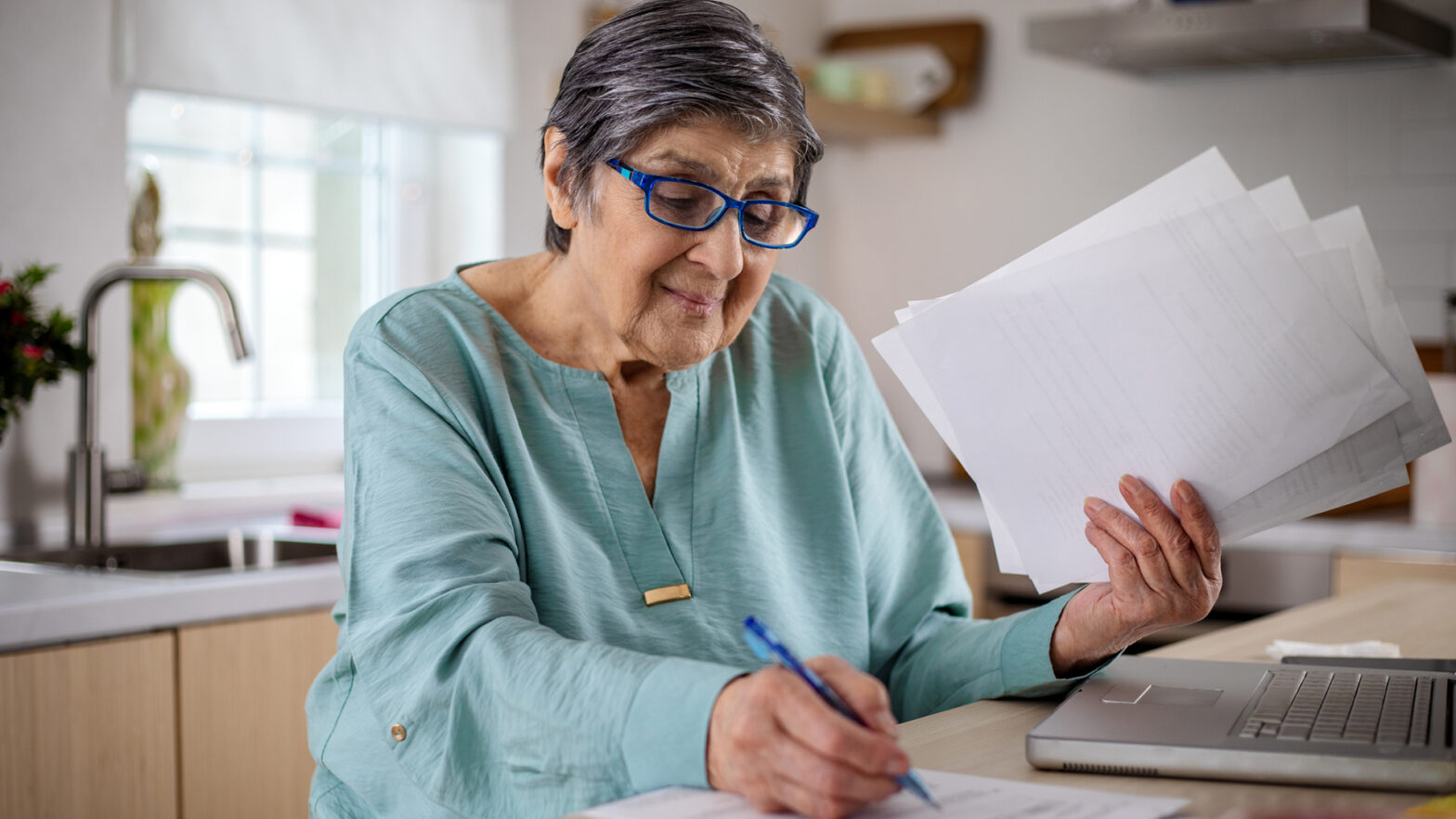 Senior woman calculating finance, money, using laptop computer, counting budget, paying bills, taxes, rent, mortgage fees