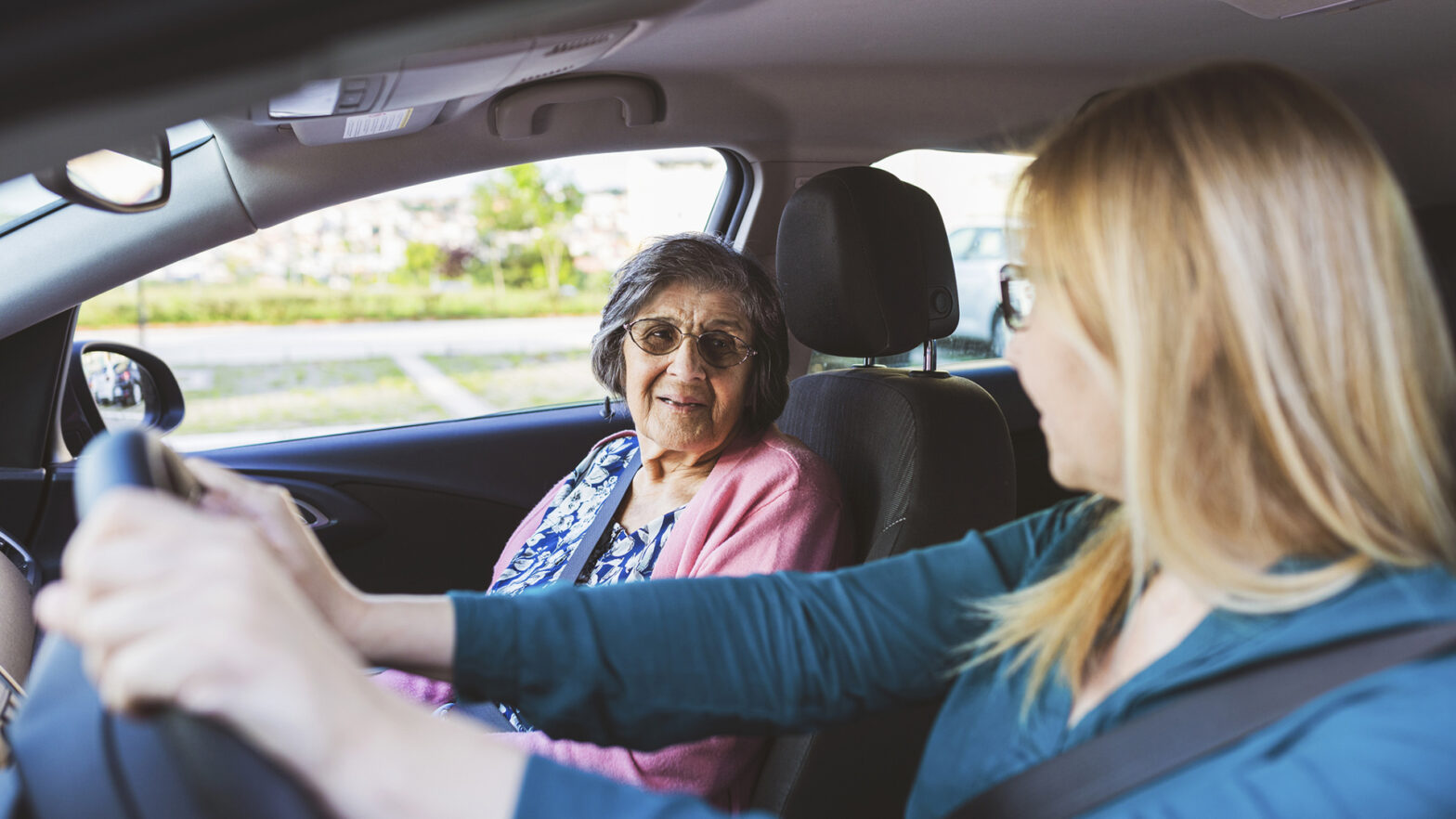 Mature woman in a car with her senior mother.They are talking and enjoy in a ride Health care and protection.