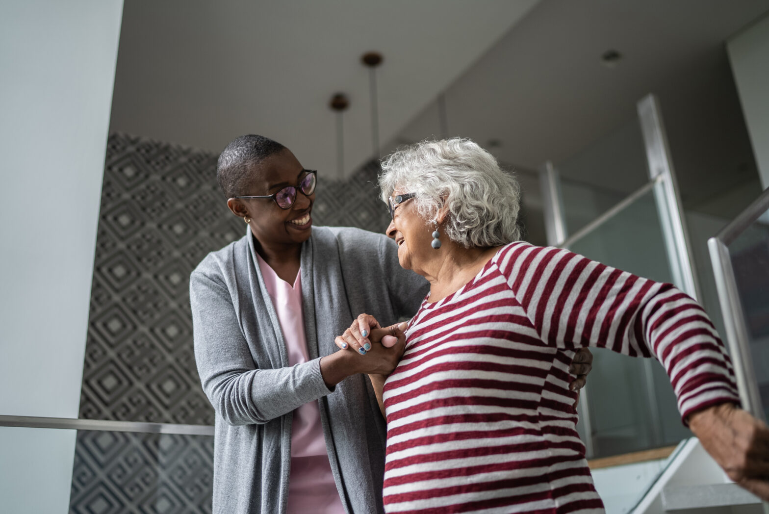 Nurse helping a senior woman walking the stairs