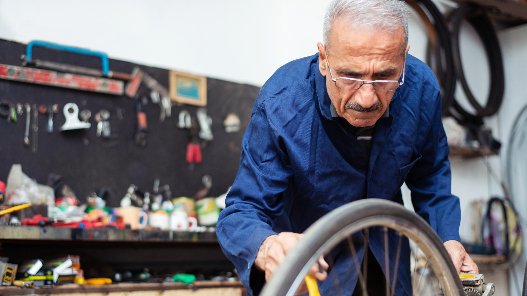 A senior bicycle mechanic working out of his shop.
