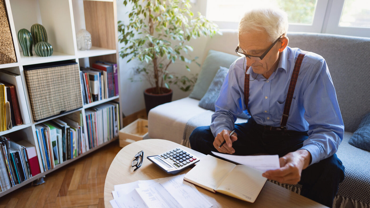 High-angle view of a senior Caucasian man calculating his finances at home.
