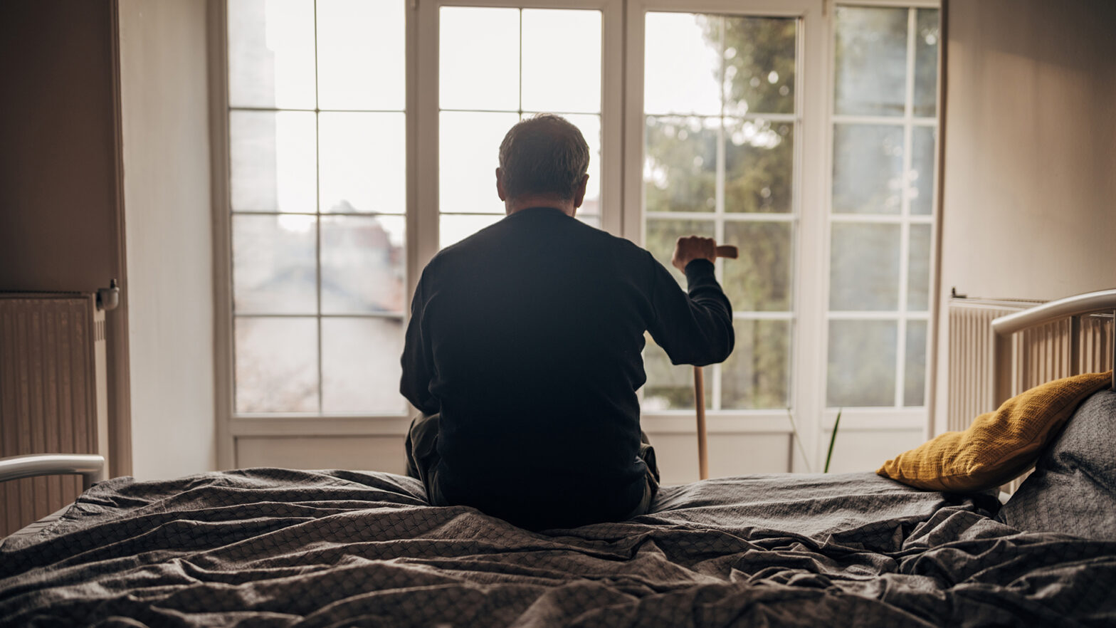 A lonely man is sitting on the bed